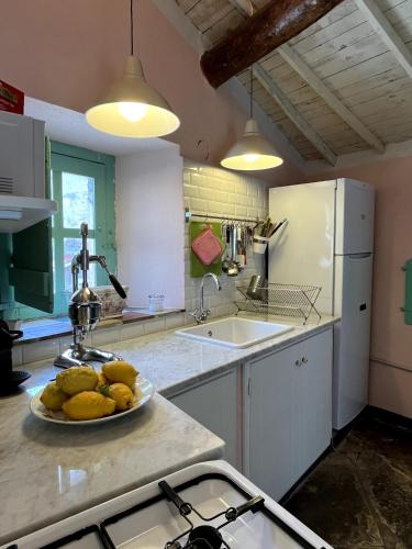 a kitchen with a plate of fruit on a counter at House in Rural Sardinia in Collinas