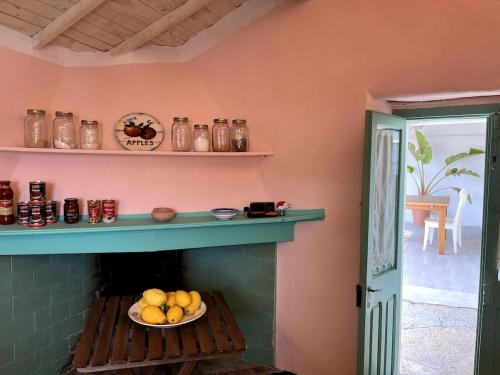a room with a fireplace with a bowl of fruit at House in Rural Sardinia in Collinas