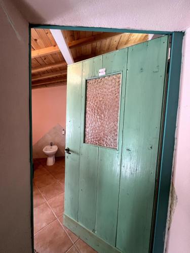 a green door in a bathroom with a toilet at House in Rural Sardinia in Collinas