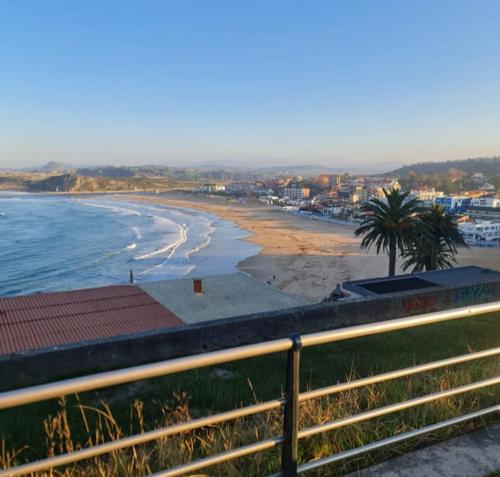 a view of a beach with palm trees and the ocean at La Casita de Suances 1 in Suances