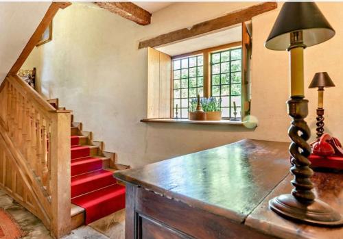 a room with a staircase and a table with a lamp at Beautiful Brecon Beacon House in Llandovery