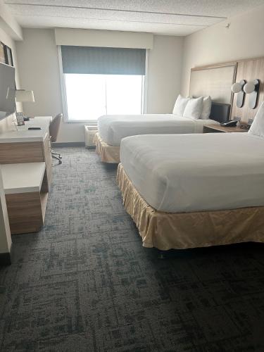a hotel room with two beds and a desk at Wingate by Wyndham Richmond Short Pump in Richmond