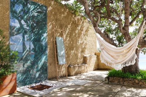 a hammock hanging from a wall next to a tree at Seashore Villa - Porto Santo in Porto Santo