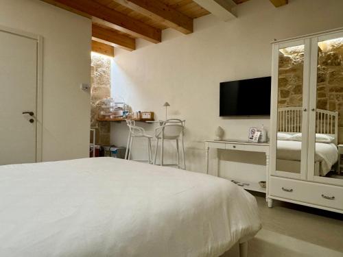 a bedroom with a bed and a desk and a television at Amurusa Room in Noto