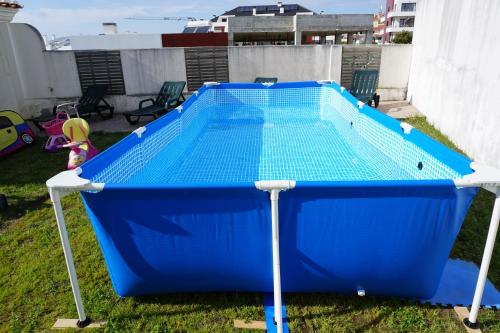a large blue trampoline in a backyard at Merci Beach House in Carvoeira