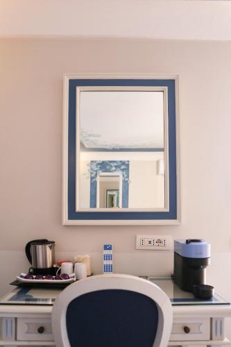 a table with a mirror and a chair in a room at Hotel Margherita in Praiano