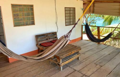 a hammock on a porch of a house at Monkey House Hostel in Tola