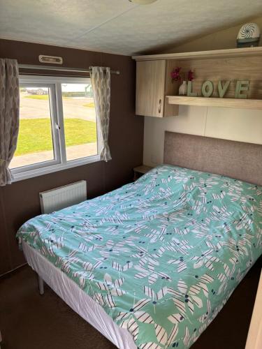 a bedroom with a bed in a caravan at Jay 35 4 bed sleeps up to 8 dog friendly caravan Thornwickbay haven site on East coast in Flamborough