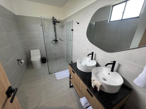 a bathroom with two sinks and a shower and a mirror at Hotel San Gil House in San Gil