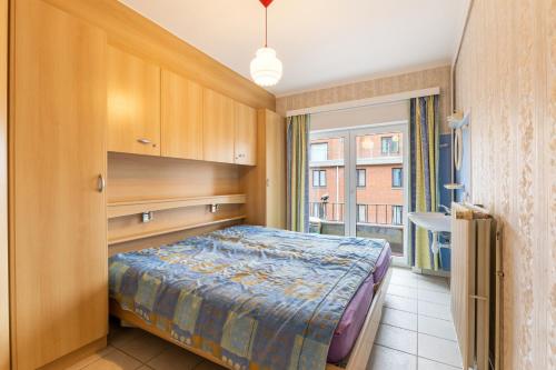 ein kleines Schlafzimmer mit einem Bett und einem Fenster in der Unterkunft Jackylène 0401 in Koksijde