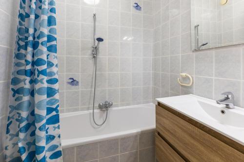 ein Badezimmer mit Badewanne, Waschbecken und Dusche in der Unterkunft Jackylène 0401 in Koksijde