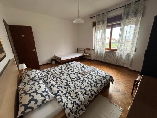 a bedroom with a bed and a window at B&B PRETITE - Artegna in Artegna