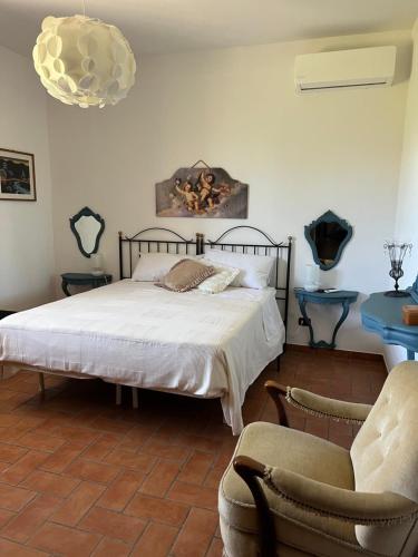 a bedroom with a bed and two chairs in it at Villa Laura in Neviano