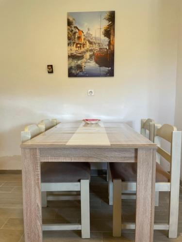 a dining room table with chairs and a painting on the wall at Summer house Kruce in Kruče