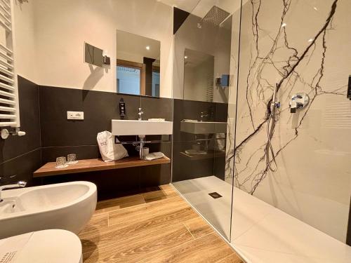 łazienka z prysznicem, toaletą i umywalką w obiekcie Hotel Aquila D'Oro Desenzano w mieście Desenzano del Garda