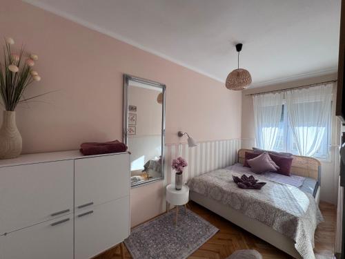 a small bedroom with a bed and a mirror at Middle of the city apartman 2 in Pécs
