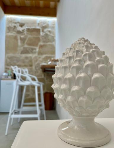 a white vase sitting on top of a table at Amurusa Room in Noto