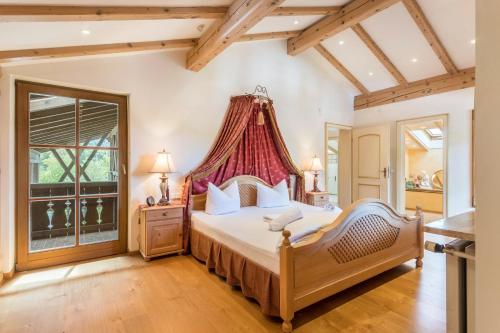 a bedroom with a large bed with a red canopy at Ferienhaus am Hochgern in Unterwössen