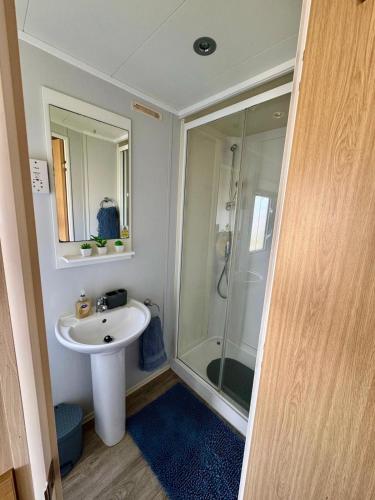 a bathroom with a sink and a shower at Reeva's Retreat at Littlesea Holiday Park, Weymouth in Wyke Regis
