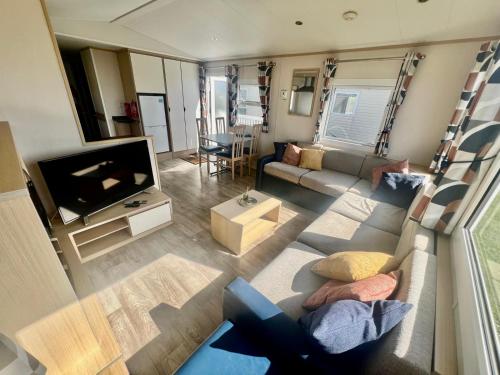 a living room with a couch and a tv at Reeva's Retreat at Littlesea Holiday Park, Weymouth in Wyke Regis