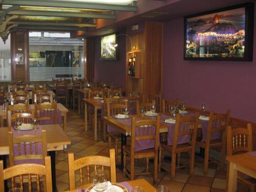 un comedor con mesas y sillas en un restaurante en Hostal Linar, en A Coruña