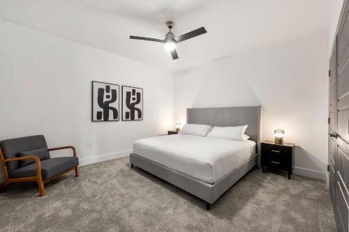 a white bedroom with a bed and a chair at The Nomad ATL in Atlanta