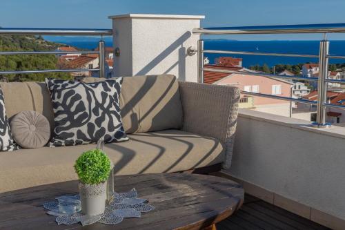 a couch sitting on a balcony with a table at Apartments Pera in Hvar