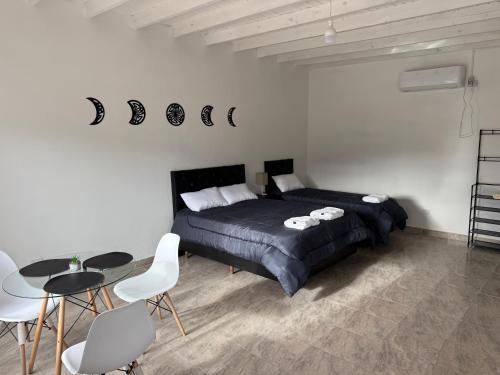 Un dormitorio con una cama y una mesa y sillas. en Complejo Laguna Brava, en Vinchina