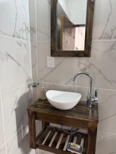 Un baño con un lavabo blanco y un espejo. en Complejo Laguna Brava, en Vinchina
