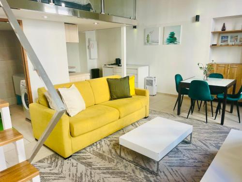 un salon avec un canapé jaune et une table dans l'établissement Alexandre Mari old town few meters to the beach, à Nice
