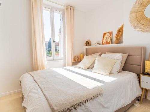 une chambre avec un grand lit blanc avec une fenêtre dans l'établissement 2-room near sea, new fully equipped, à Toulon