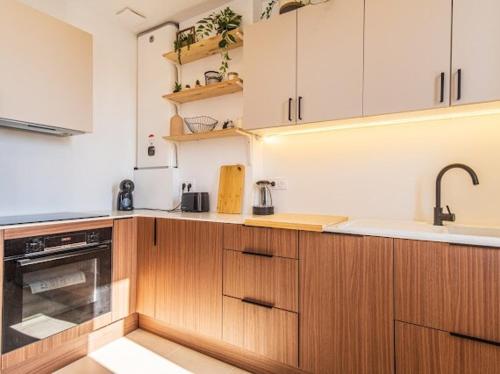 une cuisine avec des armoires en bois et un évier dans l'établissement 2-room near sea, new fully equipped, à Toulon
