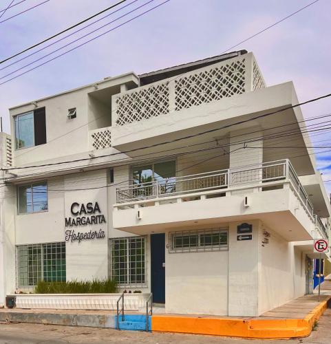 a white building with a sign on it at Hosteleria Casa Margarita in Mazatlán