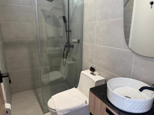 a bathroom with a shower and a toilet and a sink at Hotel San Gil House in San Gil
