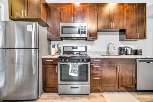 a kitchen with stainless steel appliances and wooden cabinets at Cle Suites 2BR 1BA 5 min Walk to Cle Clinic Unit 4 in Cleveland
