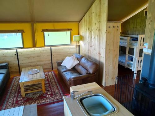 a living room with a couch and a table at Beara Lodge Glamping in Beaworthy