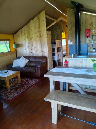 a living room with a table and a couch at Beara Lodge Glamping in Beaworthy