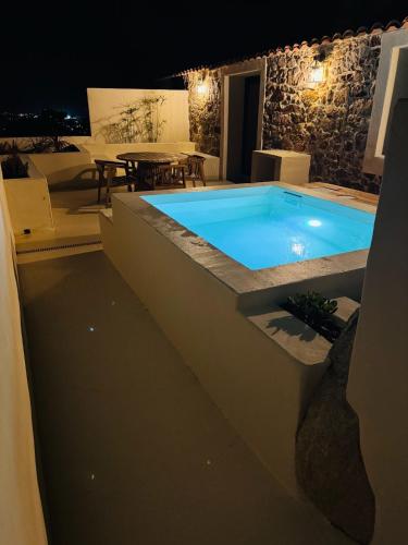 - une piscine au milieu d'un patio la nuit dans l'établissement Charmante maison en pierre vue mer et piscine privée, à Cuttoli-Corticchiato