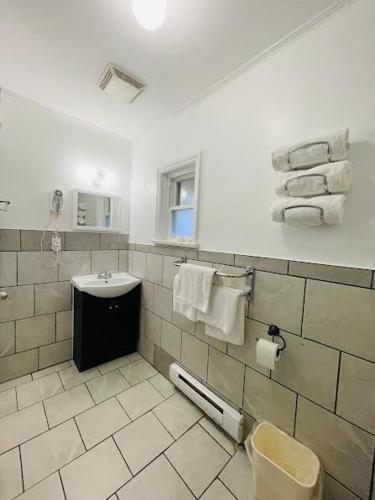 a bathroom with a sink and a toilet and towels at A1 Inn Niagara Falls in Niagara Falls
