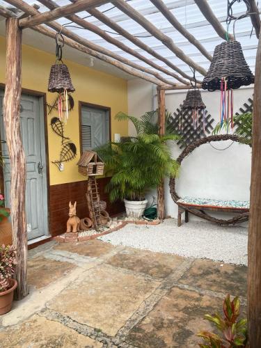 a pergola with a bed and plants in a courtyard at Bru&Mar Pousada in Parnaíba
