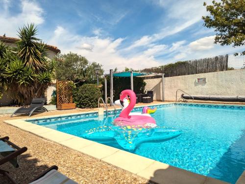 une piscine avec un cygne rose dans l'eau dans l'établissement La Closerie, à Laredorte