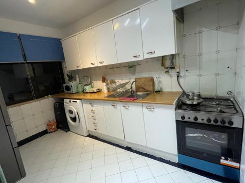 a kitchen with white cabinets and a stove at Home Away from Home in Setúbal