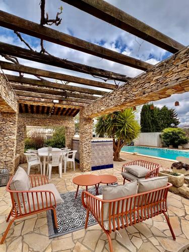 un patio avec chaises et tables et une piscine dans l'établissement La Closerie, à Laredorte