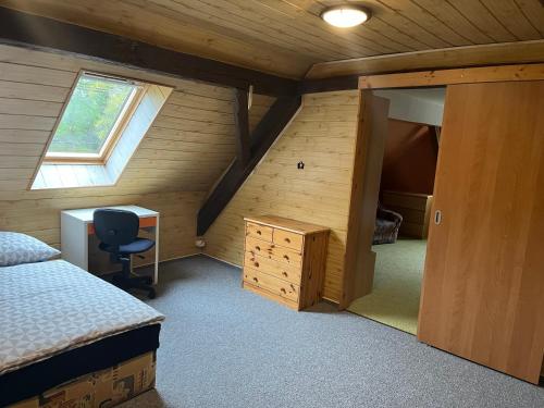 a bedroom with a bed and a desk and a window at Chalupa u Čížků in Kanice
