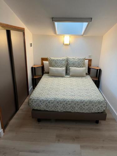 une chambre avec un lit et une lucarne dans l'établissement Mini Villa Jardin Jacuzzi, Vue mer, 300m des plages, à La Ciotat