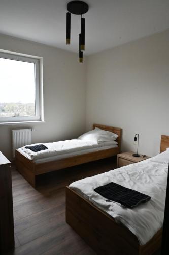 a bedroom with two beds and a window at Apartament Podmiejska in Kalisz