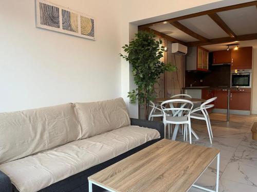 un salon avec un canapé et une table dans l'établissement Mini Villa Jardin Jacuzzi, Vue mer, 300m des plages, à La Ciotat