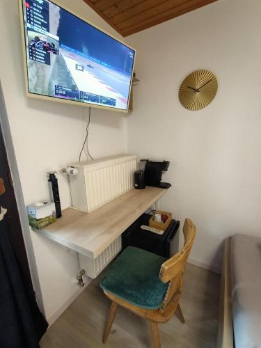 a room with a desk with a television on the wall at Herzogberghof in Kindberg