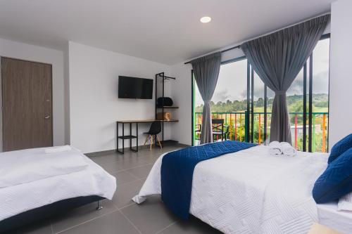 a bedroom with two beds and a balcony at Guatapé Country House Hotel in Guatapé