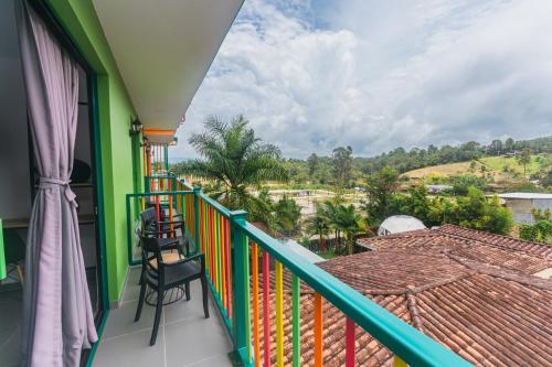 a balcony with chairs and a view of the countryside at Guatapé Country House Hotel in Guatapé